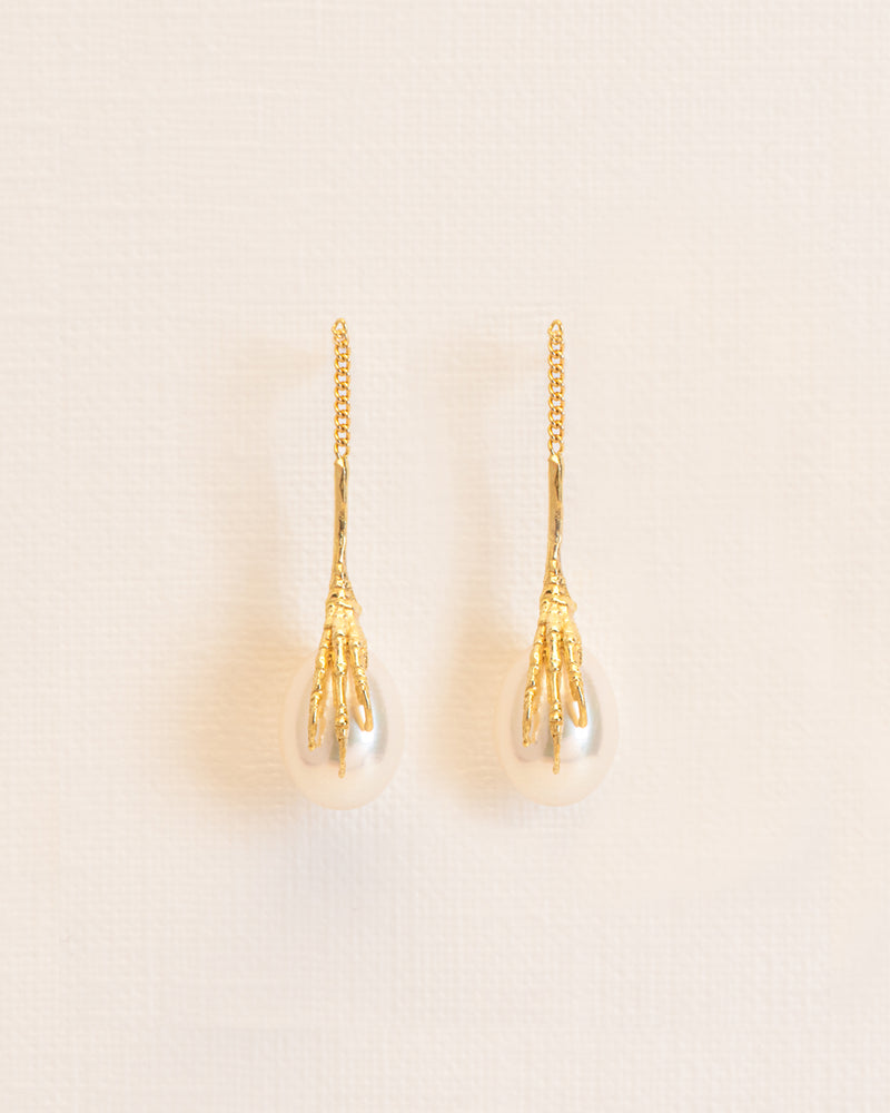Long signature grigri stud earrings clasping a pearl in 18 ct. gold