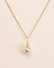 Necklace with signature grigri clasping a pearl in 18 ct. gold