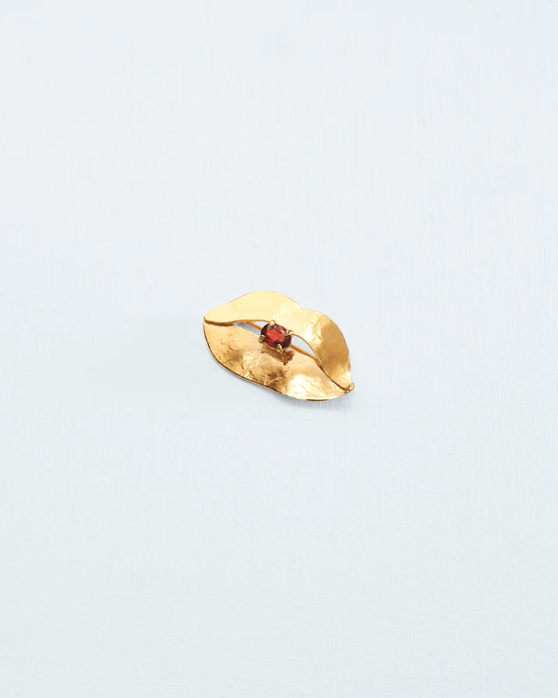 Small lip brooch with garnet